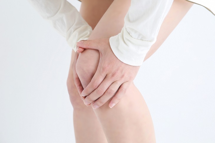 膝を押さえている女性