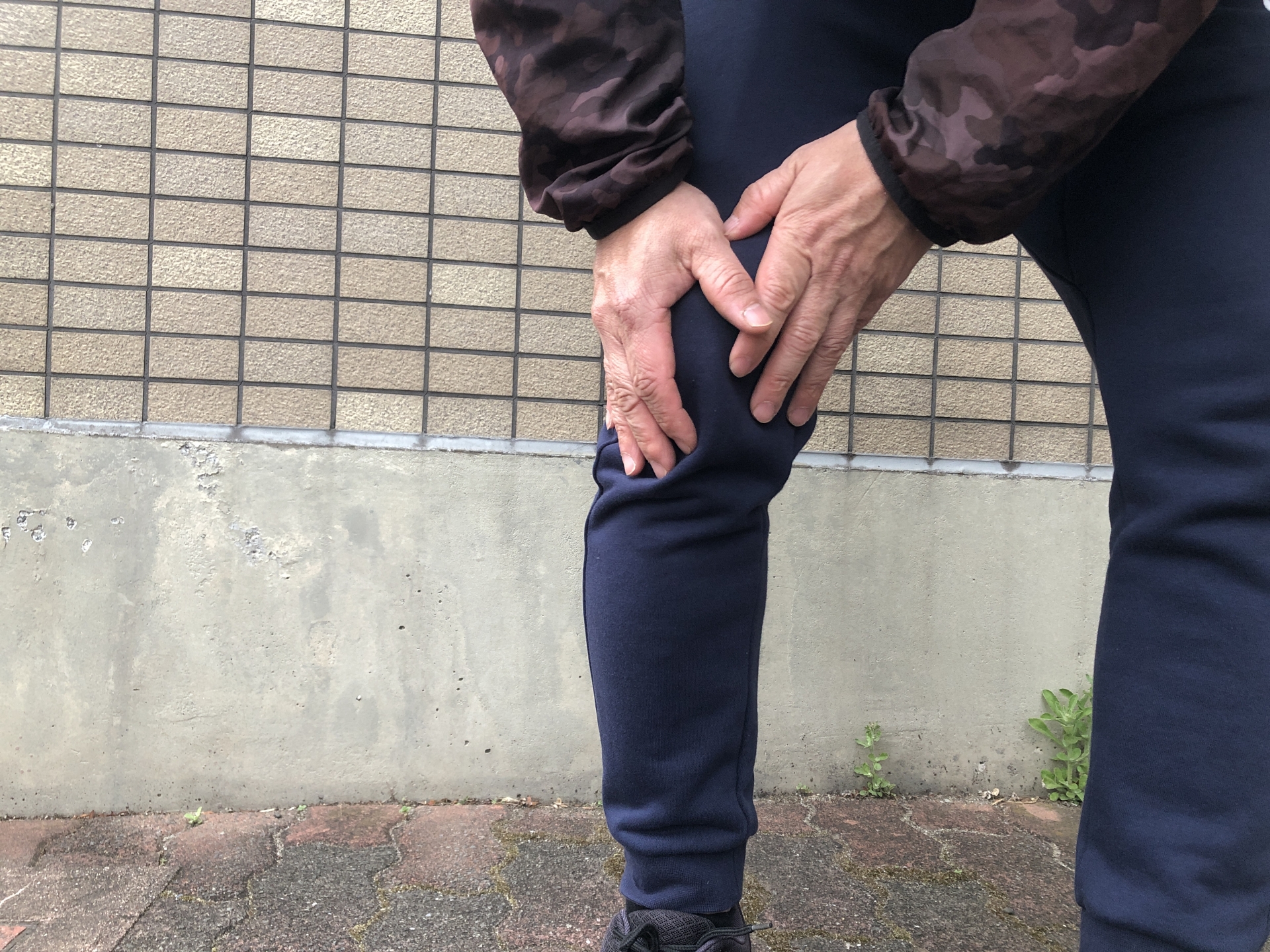 手で膝を押さえている男性