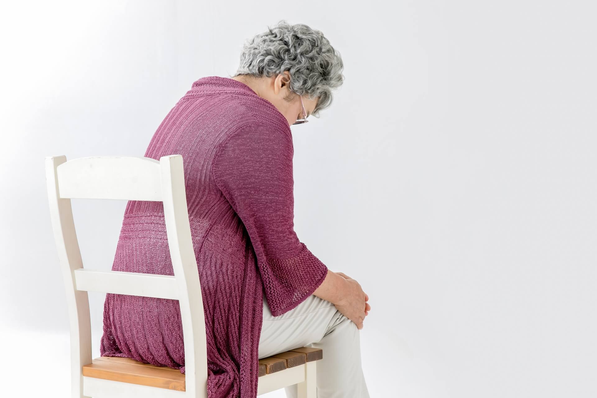 椅子に座って膝を押さえている女性